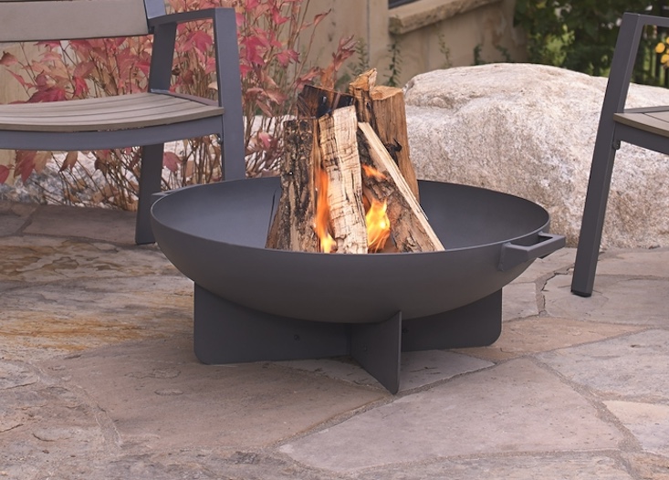 The Anson Wood Burning Fire Bowl comes with spark screen, log poker tool, grate, and protective storage cover; \$374 at Birch Lane.