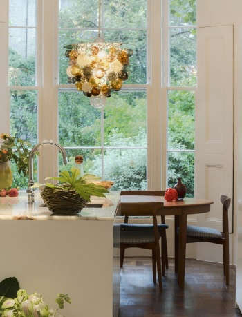 colourful glass baubles pendant, bay window overlooking garden, white kitchen island, mid-century modern table and chairs