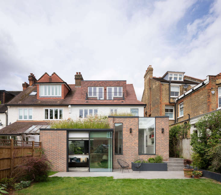 Behind the modern addition, which houses the kitchen and dining areas, is the original home, built in the early \1900s. The residence is in South West London, a conservation area close to the River Thames.