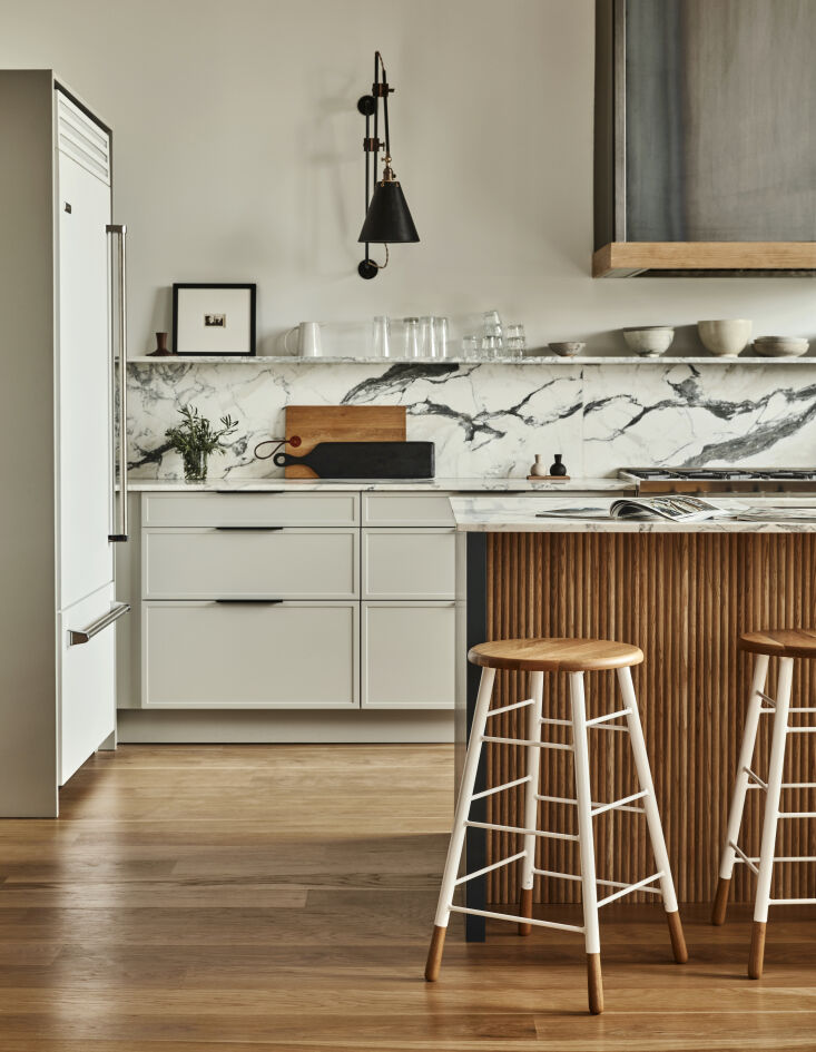 Choosing Ikea base cabinets with Semihandmade cabinet fronts meant the homeowners could splurge on other details, including these stools. Photograph by Jason Varney, from Remodelista Reconnaissance: Two-Tone Counter Stools in a Photographer’s Kitchen.