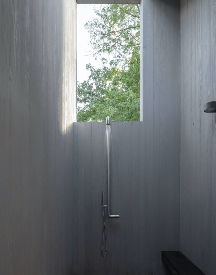The outdoor shower, with an opening that frames the tree canopy. The shower is from Jee-O.