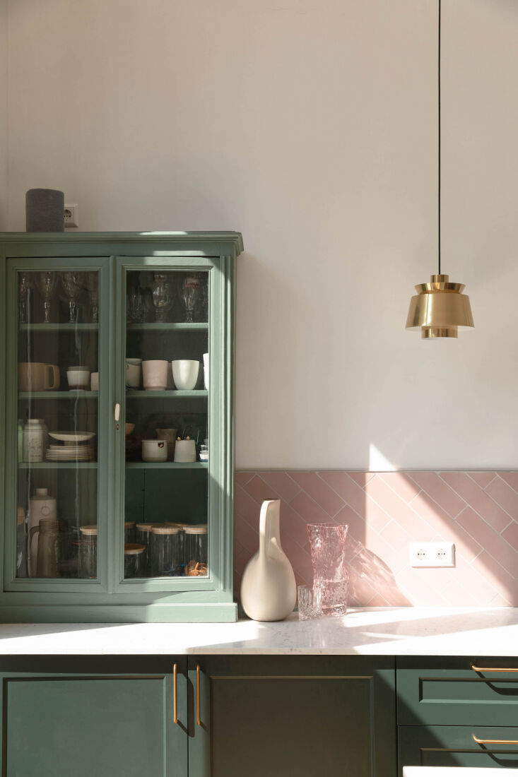 An inexpensive workaround: a vintage hutch was placed on top of the kitchen counter and painted to coordinate with the built-in cabinets. Photograph courtesy of House of Bullet, from Steal This Look: A Vintage-Inspired Pink and Green Kitchen in the Netherlands.