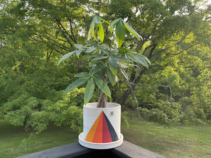 All of Michele’s stoneware planters are wheel-thrown and hand-painted with extraordinary care in her Saugerties, NY, workshop. Each has a drainage hole and comes with a catch plate. This is the Prism/Crescent Yellow Planter: It has a rainbow prism and star on one side (as shown in Michele’s backyard) and white crescent moon and yellow circle on the other; available in three sizes starting at $465.