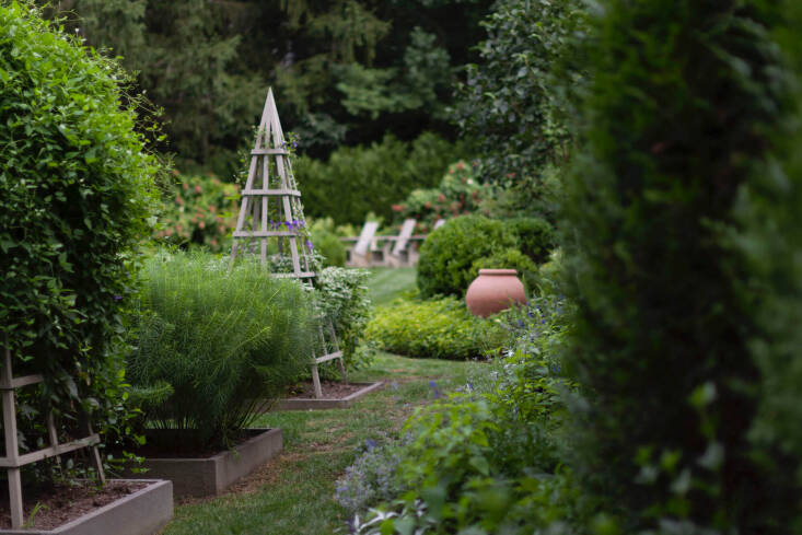 Tuteurs and oversized terra-cotta pots channel a more traditional garden.