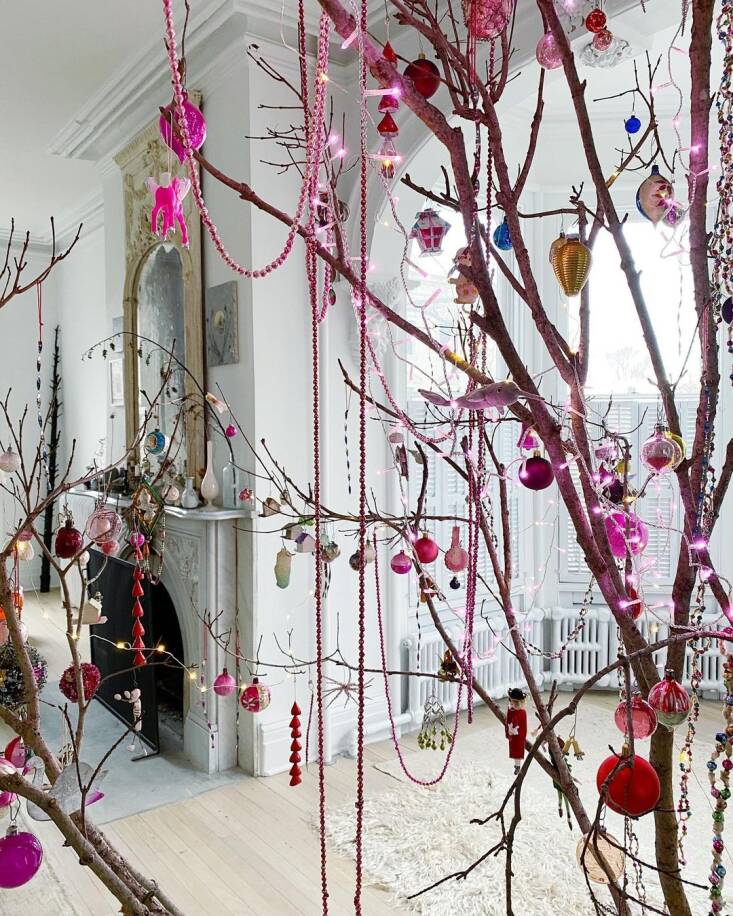 Amy decorates the branches with colorful ornaments, beads, and, of course, string lights.
