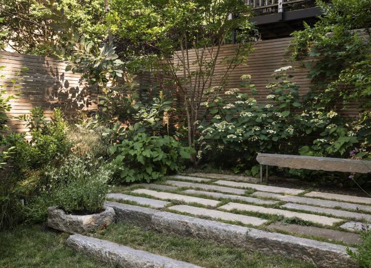 Reclaimed stone planks aligned with Farris’s clients’ desire for sustainable materials and also instantly made the garden feel more established. The furthest back section of the yard had dirt piled up post-construction, so Farris had her contractors terrace it. Upcycled granite curbs hold the higher level.