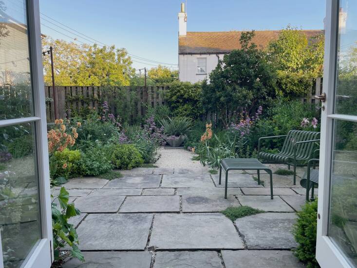 Added as part of architectural work on the house, new French doors connect the garden to the open-plan sitting room and kitchen. Morton describes the resulting indoor-outdoor space as “a place that feels like it is very private and a far away from the world outside.