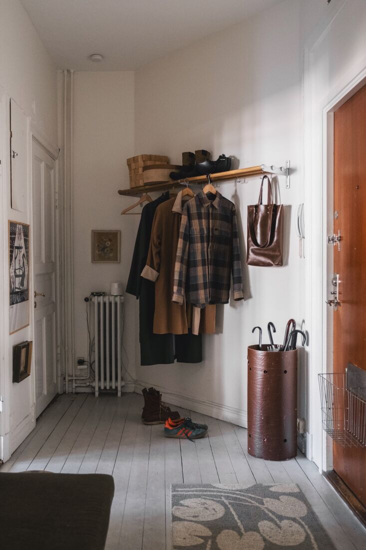 Even if you rent and live in an apartment, there may be ways to personalize your front door situation. For this shared hallway, renter Elisabeth Dunker had her landlord\2\17;s approval to rip up the floor to expose hardwood planks and decorate the space with entryway essentials like a coat rack and umbrella stand. Photograph by Elisabeth Dunker, courtesy of Fine Little Day, from Making a Rental Your Own: At Home with Swedish Artist Elisabeth Dunker of Fine Little Day.