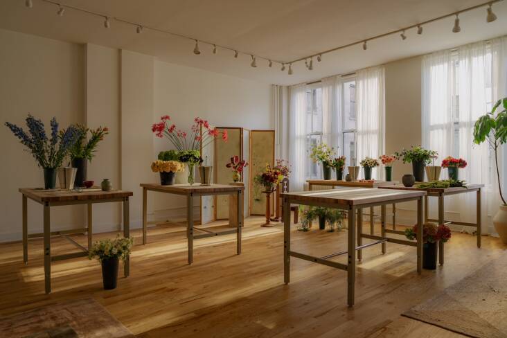 Raise-and-lower butcher-block-topped steel work tables from Global Industrial can be grouped in various ways for parties and workshops. The wooden flooring and track lighting came with the space—they\2\17;re holdovers from its lighting showroom days.