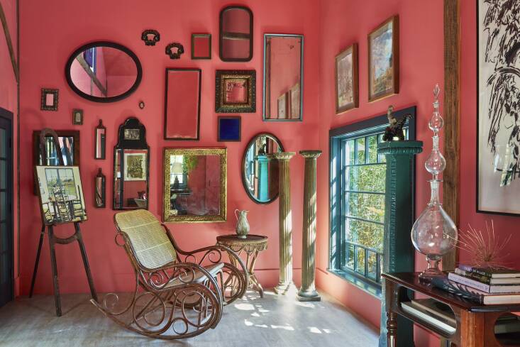 The wall of mirrors in the red living room of the Summer House remain where Dash hung them. While the double bentwood rocker is positioned to face the low picture window and its view of the Secret Garden (seen above). To the left is Dash’s \197\2 painting of the dining area.
