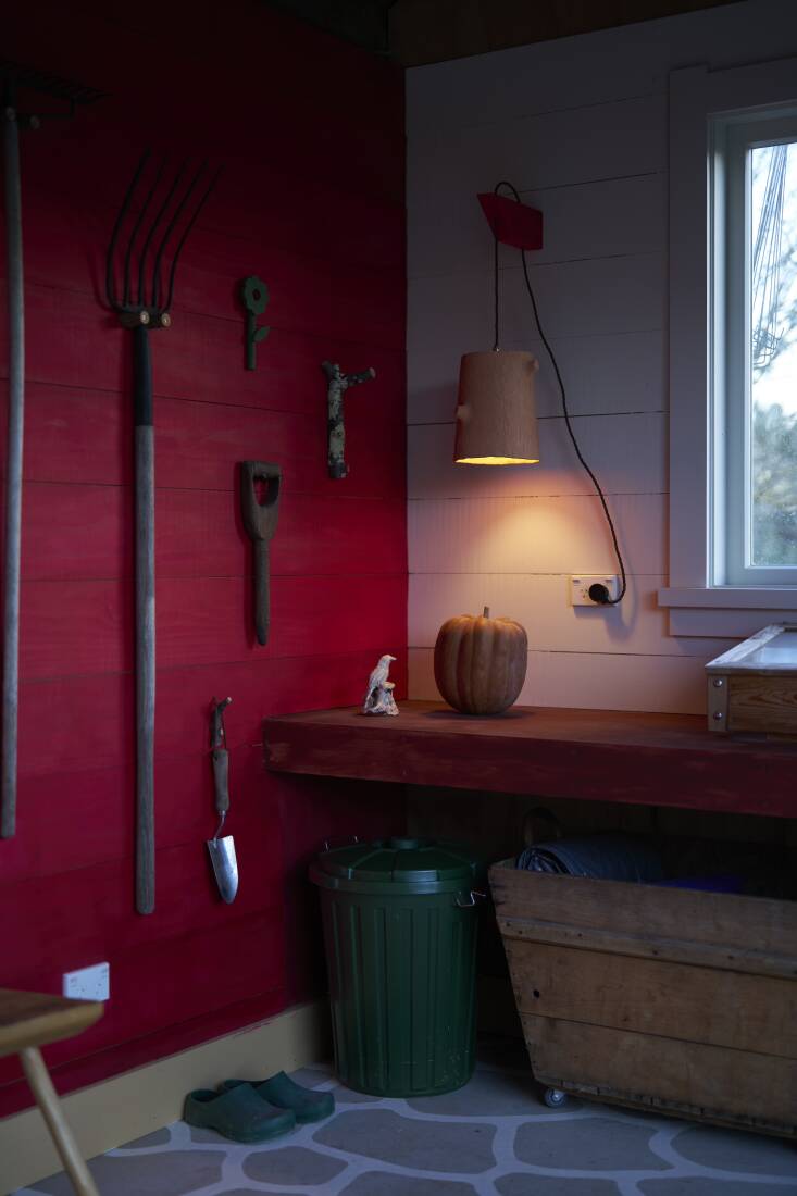 Leanne crafted the hanging lamp. \2\20;I thought it would be nice to have some atmosphere in the late evening, and I imagined Hadley working in there on a warm summer evening,\2\2\1; she shares. A vintage champagne crate was repurposed as a storage bin for garden cloths that Hadley uses for insect prevention and creating microclimates. The green bin holds \2\20;sheep nuts,\2\2\1; which are \2\20;treats for our pet sheep,\2\2\1; explains Hadley.