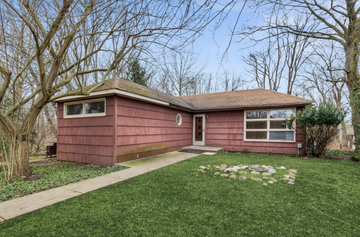 The real estate listing photo of the home, complete with an AI\2\17;d lawn. (In reality, the front yard was more dirt than grass.) \2\20;The house sits on four acres, although three acres of that is thick woods,\2\2\1; says Kim. \2\20;The one acre we had to work with felt like the biggest challenge for us, especially coming from postage-stamp yards in the city!\2\2\1;