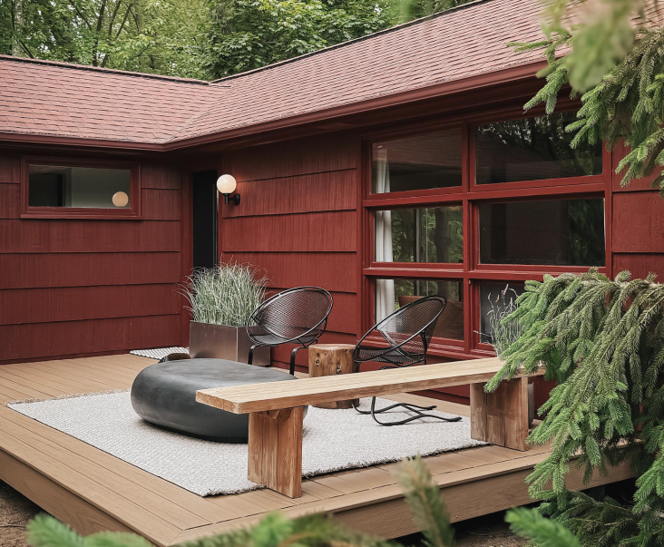 The wall light is a budget find from Wayfair, as is the Corten Steel Planter under it. A pair of vintage Salterini Radar chairs and a Pebble Concrete Coffee Table (from Crate & Barrel) anchor the deck.