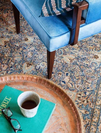 Indigo & Ochre Design Westchester living room antique Tabriz rug with vintage velvet chair & Moroccan tray table